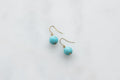 Turquoise drop earrings on marble