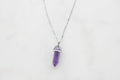 Violet crystal point pendant on marble