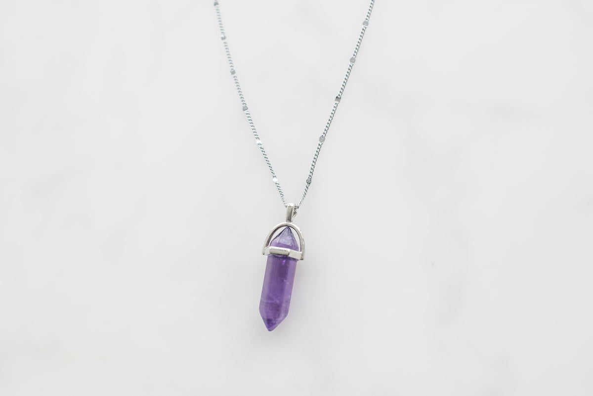 Violet crystal point pendant on marble